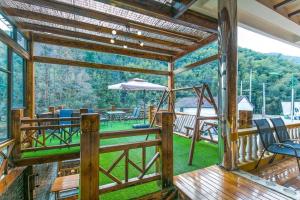 a screened in porch with a table and an umbrella at 莫干山后舍民宿 in Deqing