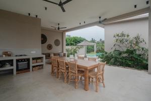 a kitchen and dining room with a wooden table and chairs at Tayo Villa in Ahangama