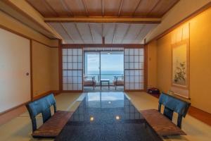 a dining room with a table and chairs and the ocean at Kissho Caren in Higashiizu