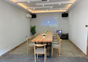 a conference room with a wooden table and chairs at 莫干山后舍民宿 in Deqing