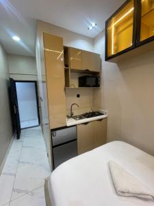 a small kitchen with a sink and a stove at Tiny Studio Apartment with Pool and gym in Lekki