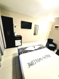 a hotel room with a bed and a television at Red Palm Hotel in Suva