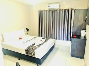 a bedroom with a bed and a window at Red Palm Hotel in Suva