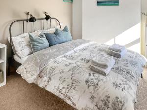 a bed with towels and pillows on top of it at Waverley Cottage in Mundesley