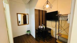 a room with a table and a television and a mirror at TC Maya Abaya Hotel in Kuantan