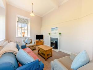 a living room with a blue couch and a tv at The Old Bakery - Uk48319 in Berwick-Upon-Tweed