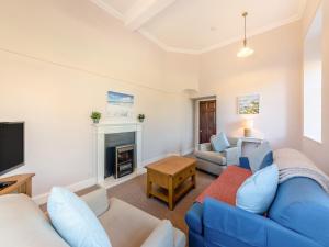 a living room with a blue couch and a fireplace at The Old Bakery - Uk48319 in Berwick-Upon-Tweed