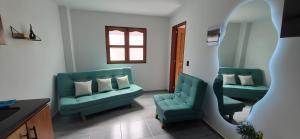 a living room with two green couches and a mirror at Portón del Río Jericó in Jericó