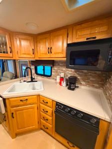 a kitchen with a sink and a microwave at comfortable home on wheels in Gadsden