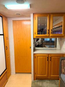 a kitchen with wooden cabinets and a door at comfortable home on wheels in Gadsden +2 photos