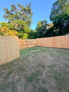 a backyard with a wooden fence and a yard at comfortable home on wheels in Gadsden