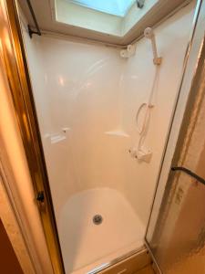 a shower with a glass door in a bathroom at comfortable home on wheels in Gadsden