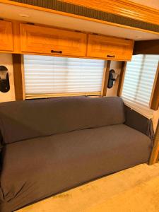 a couch in an rv with a window at comfortable home on wheels in Gadsden