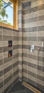 a bathroom with a black and white tiled wall at The Oceans Edge in Dodanduwa +8 photos