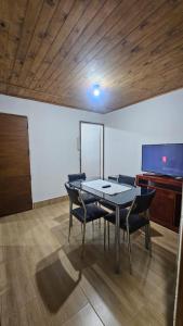 a dining room with a table and chairs and a flat screen tv at Hospedaje J & L 2 in Uspallata