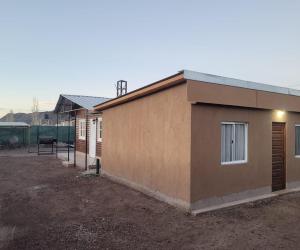 a small brown building with a window on the side at Hospedaje J & L 2 in Uspallata