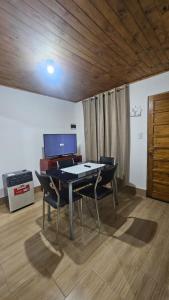 a table and chairs in a room with a piano at Hospedaje J & L 2 in Uspallata