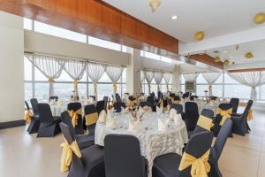 a banquet hall with tables and chairs with yellow bows at Crown Regency Hotel & Towers in Cebu City