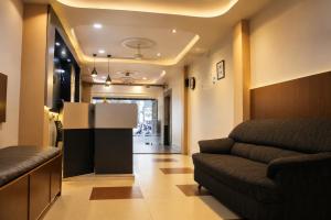 a living room with a couch and a table at Hotel Sri Ram in Similigurha +11 photos