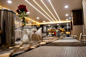 a table with a rose in a vase on it at Hotel Sri Ram in Similigurha