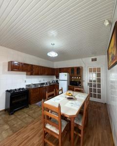 a kitchen with a table with chairs and a stove at Casa Bella Vita in Pinto Bandeira