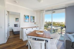 a living room with a table and chairs with a view at Pumicestone Blue in Caloundra