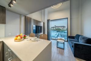 a kitchen and living room with a couch and a table at Aster Apartments - Stylish Loft with Rooftop Pool & Sauna in Canggu
