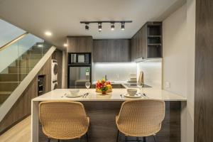 a kitchen with a table and chairs and a staircase at Aster Apartments - Stylish Loft with Rooftop Pool & Sauna in Canggu