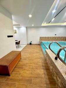 a swimming pool in a room with a table at Ujang Guest House 2 in Batu Kikir