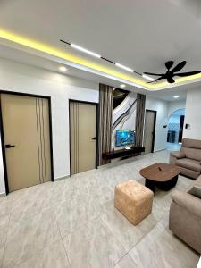 a living room with a ceiling fan and a couch and a table at Ujang Guest House 2 in Batu Kikir