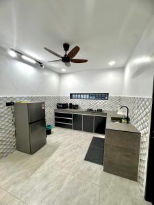 a kitchen with a ceiling fan in a room at Ujang Guest House 2 in Batu Kikir