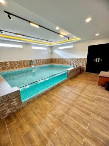 a large swimming pool in a building at Ujang Guest House 2 in Batu Kikir