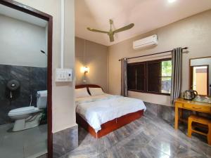 a bedroom with a bed and a bathroom with a toilet at Khamphouy Guesthouse in Champasak +45 photos