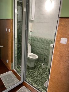 a bathroom with a toilet and a glass shower door at Art Studios Elsor in Burgas +35 photos