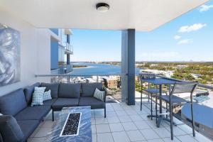 a living room with a couch and a table at Pumicestone Blue in Caloundra