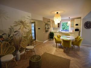 a living room with a table and yellow chairs at Comfortable Jacuzzi Apartment for 8 in Stezyca in Stężyca