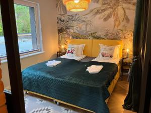 a bedroom with a bed with two towels on it at Comfortable Jacuzzi Apartment for 8 in Stezyca in Stężyca