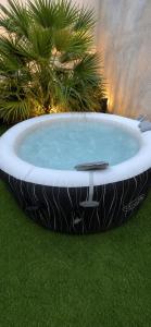a large bath tub sitting on the grass at L'Interdite House - Limitless - Jacuzzi Cinema Love in Savigny-sur-Orge