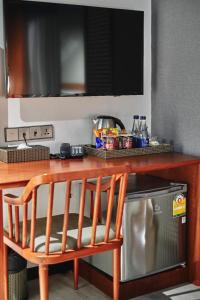 a wooden table with a microwave and a television at Sib Kao in Bangkok