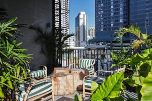 a patio with chairs and trees and buildings at Sib Kao in Bangkok