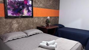 a bedroom with a bed with two towels on it at Pousada Moaçara in Estivado