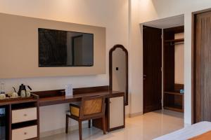 a room with a desk with a mirror and a chair at Ranggen Ubud in Ubud