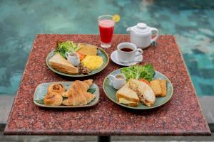 two plates of breakfast food on a table with coffee at Ranggen Ubud in Ubud