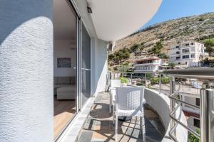 a balcony with two chairs and a view of a city at Villa Virginia in Sarandë