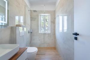 a white bathroom with a toilet and a sink at Villa Virginia in Sarandë +91 photos