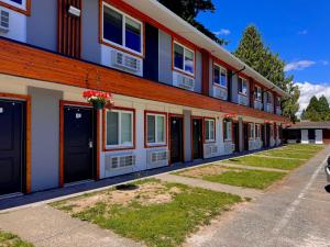 a row of buildings with doors and flowers at Alpine Inn Abbotsford in Abbotsford