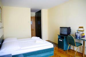 a hotel room with a bed and a television at Hotel Bara Budapest in Budapest