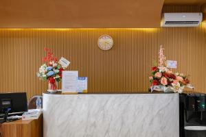 a counter with two vases of flowers on it at SANS Vibes Surya in Stasiun Tawang