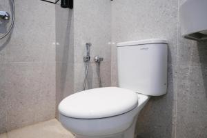 a white toilet in a bathroom with a shower at SANS Vibes Surya in Stasiun Tawang +42 photos