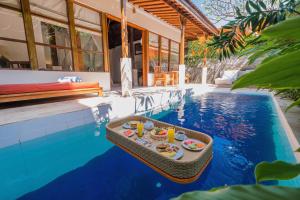 a tray of food sitting on a table next to a swimming pool at Alam Bidadari Seminyak in Seminyak